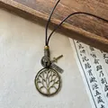 Vintage ethnic style necklace featuring a Tree of Life pendant on a rustic brown leather cord - Necklace #14 - Gold - Brown - Round