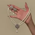 Close-up of vintage French style double-strand pearl necklace and matching drop earrings - Two-Piece Set / Silver White