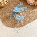 Detailed close-up of blue and pink fabric mesh flower hair clip with elegant pearl tassels - Blue
