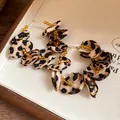 Detailed close-up of leopard print fabric petals and amber beads on hoop earrings - Coffee Leopard