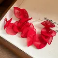 Close-up of layered red fabric petal hoop earrings with delicate red bead detailing. - Red