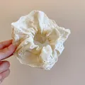 Close-up of white floral eyelet lace scrunchie with elegant ruffled texture - Floral Hollow Out Lace Scrunchie / White
