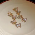 Close-up of elegant gold butterfly drop earrings with shimmering cubic zirconia - Butterfly Tassel (HE14413) / Gold