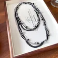 Dettaglio ravvicinato di una collana multistrato vintage con perline nere e argento - Oro-Grigio
