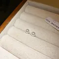 Primer plano de elegantes pendientes de perlas blancas en un joyero de tela suave. - 6mm / Blanco