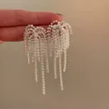 Vista macro di orecchini con nappe in argento scintillante e dettagli in strass - Stile Fioritura Argento Bianco (HE29310-1) / Stile 32# Perno in Argento S925 Argento Orecchini a Nappa a Onda