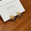 Vista dettagliata di orecchini dorati a forma di fuochi d'artificio con occhio di tigre. - Stile Oro Marrone (HE29310-1) / 33# Orecchini in Argento - Oro/Marrone