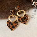 Detailed macro view of leopard print heart earrings featuring an elegant gold hollow design - Heart Shaped