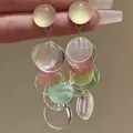 Primer plano detallado de pendientes de borlas de concha con discos translúcidos - Pendientes de botón / Multicolor