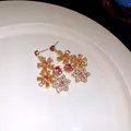 Detailed view of vintage hollow flower earrings with pink and gold crystals - Earrings / Gold-Pink