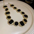 Vintage gold chain necklace with black geometric crystal stones in a macro detail view - Necklace / Black