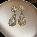 Eleganti orecchini pendenti a goccia tonalità oro impreziositi da cristalli luminosi - Orecchini pendenti / Ago d'argento / Oro Antico