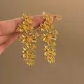 Detailansicht der goldenen Ohrhänger im französischen Blumendesign mit Vintage-Textur. - Quaste Blumenstil (8#)
