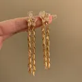 Detailansicht eleganter goldener Sternenblumen-Ohrringe mit langen Blattquasten - Pentagramm Quaste Stil (11#)