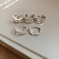 Detailed macro view of silver irregular geometric open rings with textured finishes - Style 2