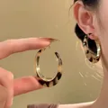 Primo piano di orecchini a cerchio leopardati retrò con finitura dorata all'orecchio - Stile 20 (N. 20) / Perno in argento 925 / Marrone oro