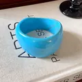 Dettaglio di un bracciale rigido in resina azzurra con texture marmorizzata irregolare - Blu