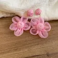 Detailed close-up view of elegant pink fabric flower earrings with soft textured petals. - 44# Silver Earring Post