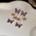 Gros plan détaillé des boucles d'oreilles pampilles papillon en cristal irisé violet - Style Papillon à Glands / Bleu et Violet