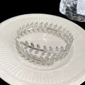 Vista dettagliata di un elegante bracciale a foglia d'argento su piatto ceramico - Bracciale Foglia (HB1116) / Argento