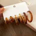 Detailed view of vintage amber resin earring set with water drop and hoop styles - Brown
