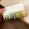 Close-up of retro earring set featuring colorful resin hoops and gold-tone earrings - Gold-Pink-Blue-Green