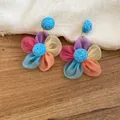 Detailed view of colorful fabric flower stud earrings on a rustic wooden background - Color-Block Floral Style (62#) / Silver Needle / Blue & Multi-color