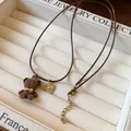 Primo piano di una collana con ciondolo a forma di orso marrone floccato - Orso Flaccato (HN7956) / Marrone oro