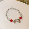Elegant white cat's eye bead bracelet with red accents and a silver wealth charm - Lucky Bell (31#)