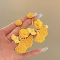 Detailed macro shot of yellow raffia floral drop earrings with woven petal textures - Leaf Flower Style (4#)