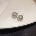 Primer plano de elegantes pendientes de perlas vintage francesas con brillo metálico - Estilo Aguja de Plata Gris / 14mm
