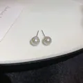 Vista macro detallada de elegantes pendientes de perlas blancas con pasador de plata pura. - Estilo Aguja de Plata Gris / 8mm