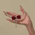 Detailed view of the red velvet bow and crystal tassels on this elegant necklace - Red