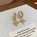 Κοντινό πλάνο χρυσών σκουλαρικιών ρόμβου με μαργαριτάρια και ζιργκόν σε vintage κάρτα. - Διάτρητο Ρομβοειδές Παράθυρο (120#) / Χρυσό
