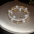 Primer plano del brazalete de perlas y diamantes de imitación con acabado dorado - Dorado