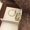 Orecchini a cerchio in oro testurizzati con motivo a croce minimalista e aghi in argento - Oro Caffè Chiaro