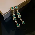 Elegantes pendientes largos geométricos con cristales verde esmeralda y baño de oro - Estilo Largo Empalmado Geométrico (HE6362) / Verde