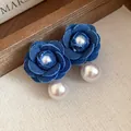 Dettaglio in primo piano di orecchini a fiore di denim blu con eleganti pendenti in perla - Stile Perla / Perno in argento 925 / Blu
