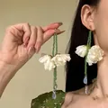 Detailansicht von eleganten langen Ohrringen mit grünen Perlen und weißen Bastblumen - Grün Weiß Blau Langer Perlenstil (8# Silberstift)
