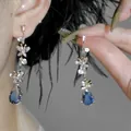 Close-up of elegant butterfly drop earrings featuring sparkling blue teardrop crystals. - 1# Silver Pin - Gold