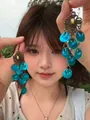 Asian model holding blue translucent flower tassel drop earrings in natural light - 11# Ear Hook Style
