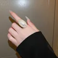 Elegant large oval pearl ring on finger showcasing a chic minimalist French style aesthetic - French Big Pearl Style (WR271) / Gold