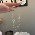 Dettaglio ravvicinato di una collana a più strati di perle di vetro trasparenti in mano - Perline di Vetro Multistrato (Bianco)