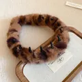 Detail view of a plush leopard print headband showing soft fur texture and inner teeth. - Light Coffee (Leopard)