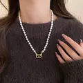 Close-up detail of a French retro faux pearl necklace featuring a gold CD logo pendant - Letter CD Rhinestone Pearl (32#)