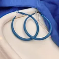 Gros plan de grandes créoles bleu Klein vernies avec tiges en argent, style minimaliste - Style Rond / Diamètre 50mm / Bleu Klein
