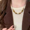 Close-up of vintage tiger eye stone necklace worn with a brown corduroy blazer - Cylindrical Tiger Eye (9#) / Gold Brown
