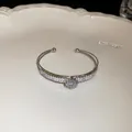 Detailed macro shot of silver double-layer cuff bracelet with sparkling zircon stones - Flower / Silver