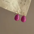 Macro shot of fuchsia enamel water drop earrings with gold-plated hooks. - Earring Hooks / Pink