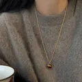 Elegant vintage round tiger eye stone pendant necklace worn over a soft brown fuzzy sweater - Round Inlaid Tiger Eye Clavicle Chain (31#) / Gold Brown